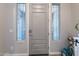 The entryway features sidelights, a grey front door, a rug, and a dark wood-look flooring at 18159 W Piro St, Goodyear, AZ 85338