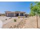 The exterior features neutral paint, a brick driveway, desert landscaping, and low-maintenance rock beds at 18159 W Piro St, Goodyear, AZ 85338