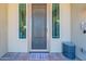 The front door features sidelights and a screen door, complemented by a rug and metal bench on the brick porch at 18159 W Piro St, Goodyear, AZ 85338