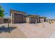 A three-car garage features neutral paint, a brick driveway, and desert landscaping under a clear blue sky at 18159 W Piro St, Goodyear, AZ 85338