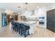 The modern kitchen has white cabinets, a center island with seating, stainless steel appliances, and dark wood-look floors at 18159 W Piro St, Goodyear, AZ 85338