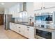 Bright kitchen featuring stainless steel appliances, white cabinets, subway tile backsplash, and a wood-look tile floor at 18159 W Piro St, Goodyear, AZ 85338