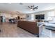 The open-concept living room features wood-look floors, a ceiling fan, and a view of the modern kitchen at 18159 W Piro St, Goodyear, AZ 85338