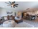 Open-concept living room featuring a leather couch, wood-look floors, and modern lighting in a neutrally painted home at 18159 W Piro St, Goodyear, AZ 85338