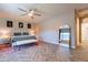 The main bedroom has a ceiling fan, sitting area, and a large mirror to add depth to the space at 18159 W Piro St, Goodyear, AZ 85338