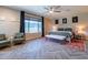 The main bedroom features a ceiling fan, sitting area, and large windows that let in plenty of natural light at 18159 W Piro St, Goodyear, AZ 85338