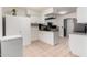 Bright kitchen with island, providing ample prep space and storage with white cabinets and tiled floor at 1818 S Toltec --, Mesa, AZ 85204