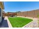 A spacious backyard featuring an artificial turf lawn, a pergola-covered patio, and desert landscaping for a low-maintenance outdoor space at 18956 W Laurel Ln, Surprise, AZ 85388