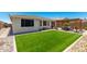 An expansive backyard with artificial turf and a pergola-covered patio, perfect for relaxation and entertainment at 18956 W Laurel Ln, Surprise, AZ 85388