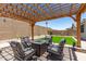 Relaxing backyard patio featuring a pergola with outdoor seating, a perfect space for entertaining guests and enjoying the outdoors at 18956 W Laurel Ln, Surprise, AZ 85388