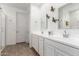 This bathroom features a dual sink vanity, sleek mirrors, and a glass-enclosed shower at 18956 W Laurel Ln, Surprise, AZ 85388