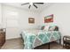 A cozy bedroom features a ceiling fan, wood-look floors, and a comfortable bed at 18956 W Laurel Ln, Surprise, AZ 85388