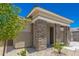 Front exterior featuring stone accents, desert landscaping, and a charming covered porch at 18956 W Laurel Ln, Surprise, AZ 85388
