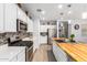 Bright kitchen showcases a wood island with sink, stainless appliances, and a mosaic backsplash at 18956 W Laurel Ln, Surprise, AZ 85388