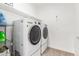 This laundry room features neutral walls, tile floors, and side-by-side white LG washer and dryer units at 18956 W Laurel Ln, Surprise, AZ 85388