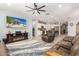 Bright living room with a large TV, fireplace, and open access to the kitchen at 18956 W Laurel Ln, Surprise, AZ 85388