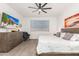 A well-lit bedroom featuring a ceiling fan, a large bed, and a mounted TV at 18956 W Laurel Ln, Surprise, AZ 85388