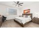 This bedroom features a ceiling fan, neutral walls, wood floors, and a decorative wall art at 18956 W Laurel Ln, Surprise, AZ 85388