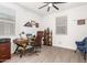 A home office space with wood floors, a ceiling fan, a wood desk, and a brown leather office chair at 18956 W Laurel Ln, Surprise, AZ 85388