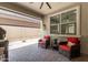 Covered back patio with pavers, an exterior sun shade, and bright-colored patio furniture at 18956 W Laurel Ln, Surprise, AZ 85388