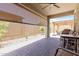 Covered back patio with brick pavers, sun shades, access to the backyard, and an overhead fan at 18956 W Laurel Ln, Surprise, AZ 85388