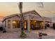 Back exterior of the home with a covered patio, brick pavers, mature trees and a cozy ambiance at 2123 S Bristol Dr, Mesa, AZ 85209