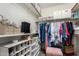 Organized walk-in closet with shelving, hanging space, and a pink ottoman at 2123 S Bristol Dr, Mesa, AZ 85209