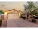Well-lit home showcasing a clean driveway, neutral exterior, and desert landscaping at 2123 S Bristol Dr, Mesa, AZ 85209