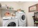 Functional laundry room with modern Samsung washer and dryer and plenty of shelf storage at 2123 S Bristol Dr, Mesa, AZ 85209