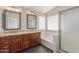 Bathroom featuring dual sinks, granite countertops, shower, and garden tub at 2257 E Lockwood St, Mesa, AZ 85213