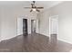 Spacious bedroom featuring hardwood floors, ceiling fan, closet, and bathroom entryways at 2257 E Lockwood St, Mesa, AZ 85213