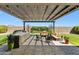 Backyard with a stone grill, covered patio, and outdoor dining set, perfect for entertaining at 22743 N 97Th Dr, Peoria, AZ 85383