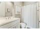 Clean and bright bathroom featuring a white vanity, toilet, and shower with a stylish black and white curtain at 22743 N 97Th Dr, Peoria, AZ 85383