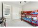 A cozy bedroom with a red bunk bed, plush carpet, and a view to another room through the doorway at 22743 N 97Th Dr, Peoria, AZ 85383