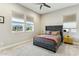 A lovely bedroom featuring a modern bed with a gray headboard, neutral walls, and bright natural light from the windows at 22743 N 97Th Dr, Peoria, AZ 85383