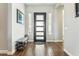 Stylish home entryway with modern front door, decorative sidelights, wood flooring, and a bench at 22743 N 97Th Dr, Peoria, AZ 85383