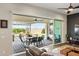 Well-lit living room with sliding glass doors to the backyard, hardwood floors, and backyard patio view at 22743 N 97Th Dr, Peoria, AZ 85383