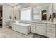 Bright main bathroom featuring dual vanities, soaking tub and walk-in shower at 22743 N 97Th Dr, Peoria, AZ 85383