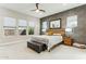 Spacious main bedroom showcasing a ceiling fan, textured wall, and three large windows at 22743 N 97Th Dr, Peoria, AZ 85383