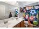 Bathroom with a double sink vanity, a large mirror and a sport themed shower curtain at 23945 N Pablo N Ct, Sun City, AZ 85373