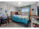 Brightly decorated bedroom with a ceiling fan, carpeted floor, and a window with blinds at 23945 N Pablo N Ct, Sun City, AZ 85373