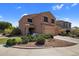 Two story home with desert landscaping, and a covered porch with seating at 23945 N Pablo N Ct, Sun City, AZ 85373