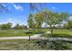 Scenic park view with a paved walking path, mature trees, and a green lawn at 23945 N Pablo N Ct, Sun City, AZ 85373