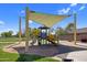 Community playground with a colorful playset, a slide, and a shaded seating area at 23945 N Pablo N Ct, Sun City, AZ 85373