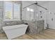 Modern bathroom features a freestanding tub, glass enclosed shower and stunning decorative tile work at 24695 S 195Th Way, Queen Creek, AZ 85142