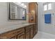 Bathroom with granite countertop, framed mirror, and wood cabinets at 24695 S 195Th Way, Queen Creek, AZ 85142