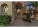 Inviting front entrance with stone archway, iron gate, and lush landscaping at dusk at 24695 S 195Th Way, Queen Creek, AZ 85142