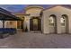 Beautiful home exterior with arched doorway, textured stucco, and outdoor seating area at 24695 S 195Th Way, Queen Creek, AZ 85142