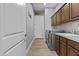 Functional laundry room includes cabinetry, utility sink, and modern appliances near garage access at 24695 S 195Th Way, Queen Creek, AZ 85142