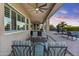 Inviting outdoor patio with comfortable seating, ceiling fans, and a view of the sparkling pool and sunset at 24695 S 195Th Way, Queen Creek, AZ 85142